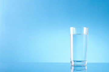 glass of pure water on a blue background