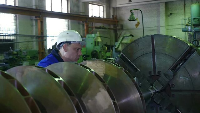 lathe operator in a factory for the production repair rotor for compressor turbine