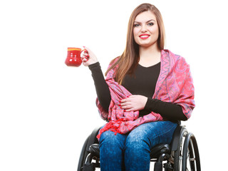 Woman invalid girl on wheelchair holds tea mug