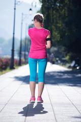 sporty woman running  on sidewalk