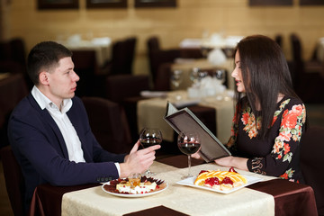 Cheerful couple with menu in a restaurant.