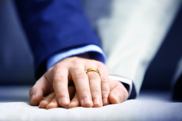 Two homosexuals holding each other hands closeup