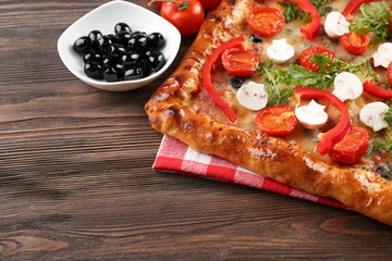 Freshly homemade pizza on wooden background