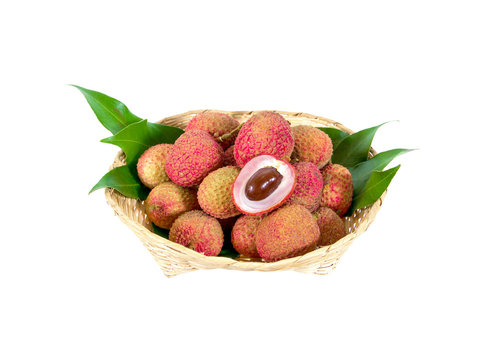 Fresh lychees fruit with leaves in small bamboo basket isolated