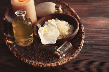 Spa set with sea salt, exotic flowers and candles on wicker tray
