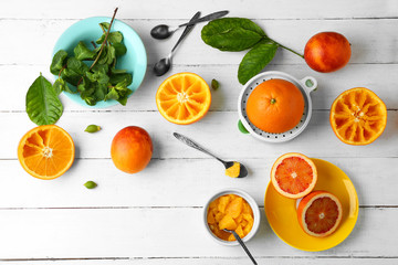 Eating oranges with spoon on white wooden background