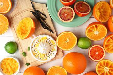 Cutting and juicing delicious oranges on white wooden table