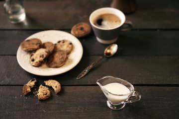 Cup of coffee with cookies on wooden table