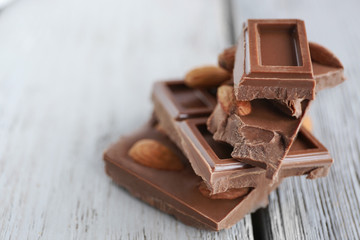 Chocolate pieces with nuts on wooden background