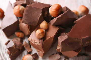 Chocolate pieces with nuts on wooden background