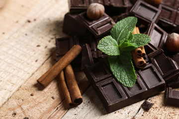 Chocolate pieces with mint leaves on wooden background