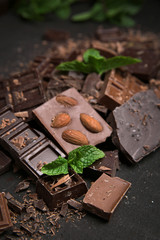 Chocolate pieces with mint leaves on black background
