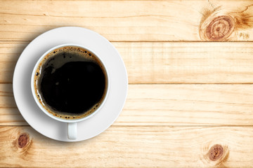Top view of coffee cup on a wood background with copy space.