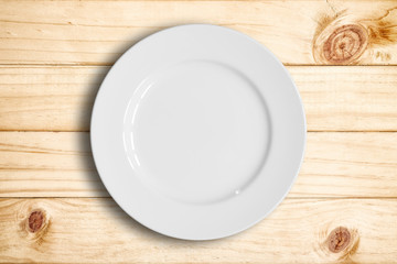 Top view of blank white dish on a wood background.