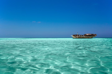 Fototapeta premium clear ocean maldives water under blue sky with abandoned boat