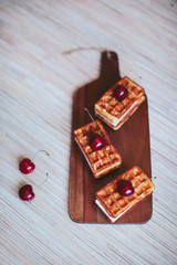 waffles with a cherry on a wooden board