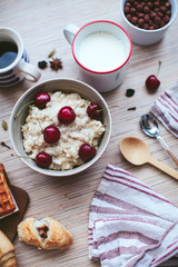 rich breakfast of porridge with cherries and pastry