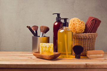 Body care products on wooden table over gray background