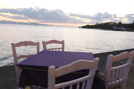 Purple table with sea views during sunset, in Aegina, Greece