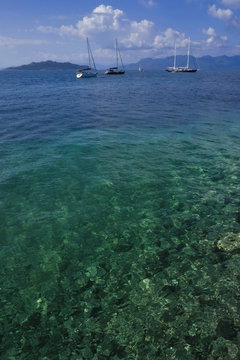 Transparent Greek Sea with boats amd island views.