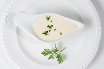 Tasty Bechamel sauce or white sauce with fresh greenery