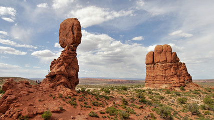 Fototapeta na wymiar Balanced Rock on a marbled sky background with sandstone towers in the foreground, Arches National Park, Utah