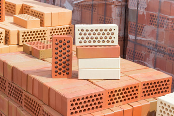 Several perforated bricks of different colors with round holes