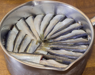 Prepared for cooking baltic herring in a stainless steel pan