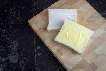 Bread with butter on a cutting board