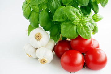 Obraz na płótnie Canvas Composition of vine tomatoes, garlic bulb and a basil plant.
