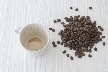 Coffee cup and beans with coffee stains have not washed the cup placed on the white table