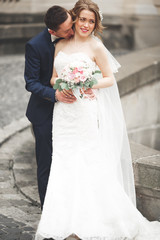 wedding couple is standing and kissing in the streets of old city