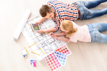Young couple choosing colors of their new flat
