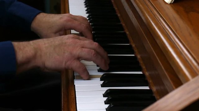 Older Male Hands Playing Slowly On Piano
