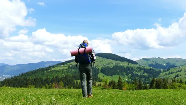 4K . Adult man  tourist go  on mountain hill in sunny day. Backpacker team