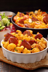 Casserole with chorizo sausage on wooden background