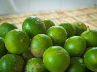 Box with green lemons on a Wood Bamboo Mat