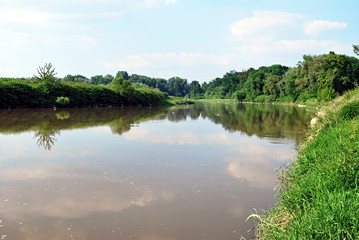 Odra river with trees around and blue sky with clouds on czech-polish boundaries near Bohumin and...