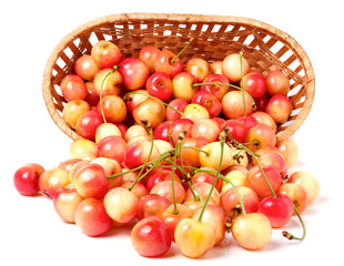 yellow cherries in a wicker basket isolated on white background