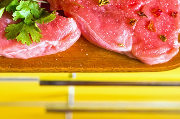 Raw pork steak - ready for cooking with herbs