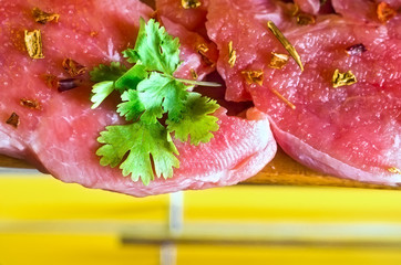 Raw pork steak - ready for cooking with herbs