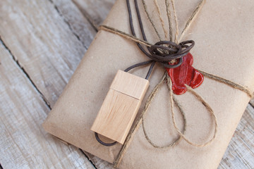 Fototapeta na wymiar The parcel wrapped in Kraft on a wooden background. The gift wra