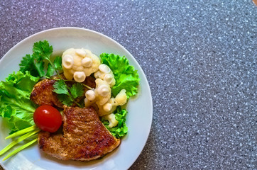 juicy grilled pork chop (neck cut) with greens