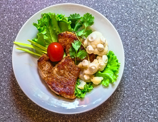 juicy grilled pork chop (neck cut) with greens