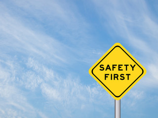 wording "Safety first" on yellow traffic sign with pole on the b