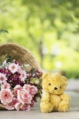 Teddy bear and beautiful flowers basket on the table with copyspace