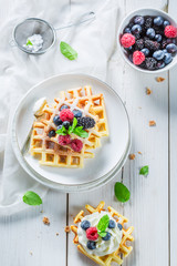 Homemade waffels with berry fruits and whipped cream