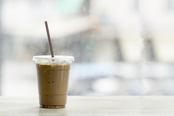 Ice coffee on wood table with blur  background with copyspace