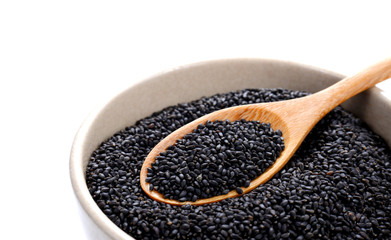 Black sesame  in wooden spoon on sesame bowl.