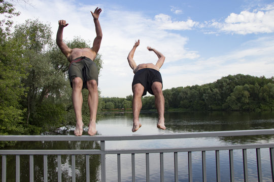 Two guys are jumping off the bridge into the river
Friends jumping together in the water
Summer swimming